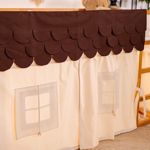 May include: A brown fabric canopy with scalloped edges and two windows, attached to a wooden bunk bed frame. The canopy is made of a light beige fabric and has a brown fabric roof with scalloped edges.