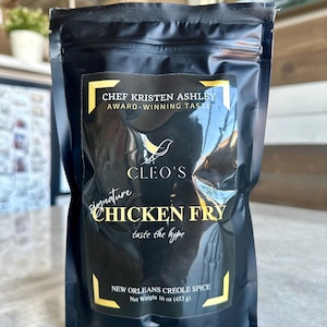 May include: Black pouch with a white label that says "Chef Kristen Ashley Award-Winning Taste Cleo's Signature Chicken Fry Taste the Hype New Orleans Creole Spice Net Weight 16 oz (453 g)"