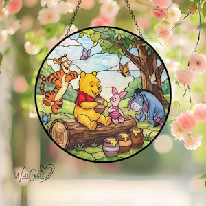Könnte beinhalten: Ein rundes Buntglasfenster mit Winnie Puuh und seinen Freunden. Die Szene zeigt Puuh, Tigger, Ferkel und I-Aah, mit Schmetterlingen und Honigtöpfen. Das Kunstwerk ist mit einem schwarzen Rahmen versehen und hängt an einer Kette.