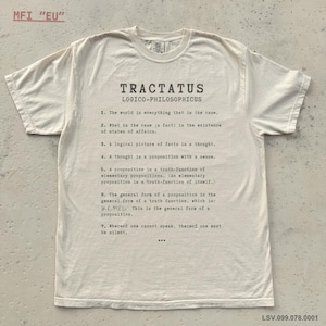 May include: Off-white t-shirt with the text "TRACTATUS LOGICO-PHILOSOPHICUS" and numbered philosophical statements in black. The shirt has a crew neck and short sleeves. The text is centered on the front.