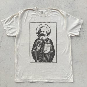 Koszulka z nadrukiem "Saint Marx" | Koszulka z grafiką "Ekonomia polityczna", "Kapitał", "Socjalizm", "Komunizm", "Materializm", "Ortodoksyjny marksizm", "W kwestii ateizmu"
