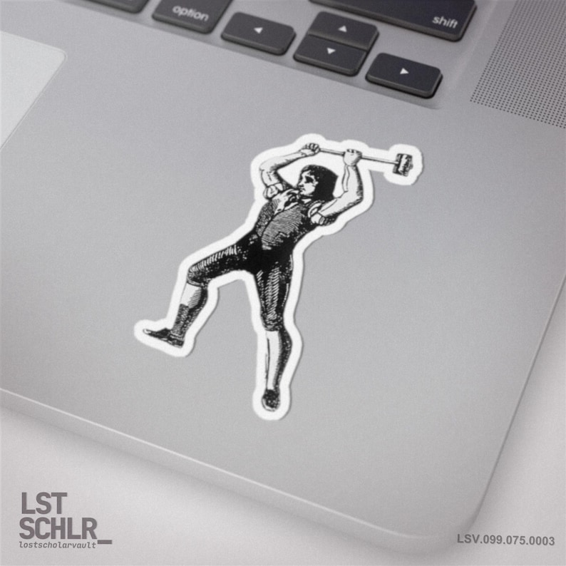 Peut inclure: Autocollant noir et blanc repr&eacute;sentant une illustration vintage d'une personne soulevant une barre. L'autocollant est sur un ordinateur portable. Le texte "LST SCHLR" et "lostscholarvault" est visible. Le num&eacute;ro de s&eacute;rie de l'autocollant est LSV.099.075.0003.