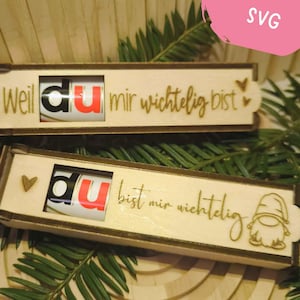 May include: Two wooden boxes with engraved text and a small chocolate bar inside. The text on the boxes reads "Weil du mir wichtig bist" and "du bist mir wichtig". The boxes are decorated with small hearts and a gnome.