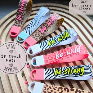 Peut inclure: Six dragonnes flexibles avec boucles, présentant divers motifs dont des imprimés léopard et des rayures zébrées. Certaines sangles affichent le texte be strong ou be wild en rose vif, jaune ou blanc. Chaque sangle a un embout en plastique uni.