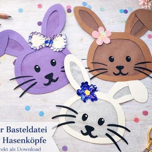 May include: Three colorful Easter bunny head cutouts. One is purple with a sequined bow, another is brown with a pink flower, and the last is white with a blue sequin flower. The image includes text in German.