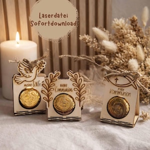 May include: Three wooden laser-cut favors with gold-wrapped candies. One favor features a dove, another has leafy branches, and the third has a fish symbol. Text on the favors reads "meine Taufe" and "meine Kommunion". A lit candle and dried flowers are in the background.