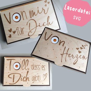 Pode incluir: Caixas de madeira com desenhos e texto cortados a laser. As caixas apresentam um acabamento em madeira clara com texto castanho escuro e detalhes de coração. Uma caixa diz "Von mir für Dich". Outra diz "Toll, dass es Dich gibt!"