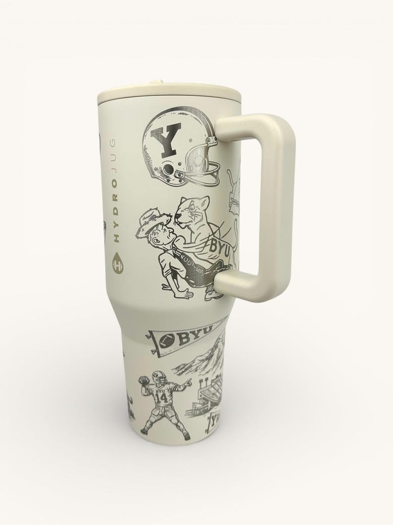 以下が含まれることがあります： クリーム色のHydro Jug（ハイドロジャグ）で、ハンドル付き。アメフトのヘルメット、フットボール選手、その他のグラフィックの白黒イラストが特徴です。ジャグには、お揃いのクリーム色の蓋が付いています。