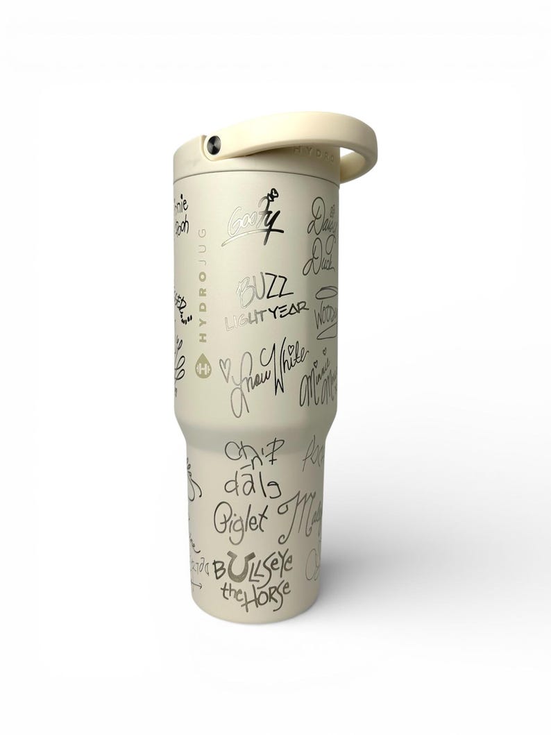 Puede incluir: Vaso aislado de color crema con asa y tapa de rosca. El vaso est&aacute; cubierto con escritura negra, incluidas las palabras "Buzz Lightyear" y otros nombres de personajes. La palabra "HYDROJUG" est&aacute; impresa verticalmente en el lateral.