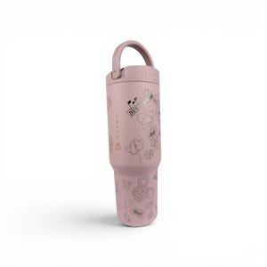 May include: A dusty rose-colored insulated tumbler with a matching handle and lid. The exterior features a repeating pattern of line-art icons including a castle, mouse ears, balloons, and tickets, with the text Disneyland and Magic printed on it.