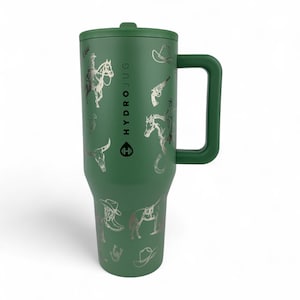 Puede incluir: HydroJug verde con asa y tapa, adornado con ilustraciones plateadas con tem&aacute;tica de vaqueros. El dise&ntilde;o incluye im&aacute;genes de un vaquero a caballo, un sombrero de vaquero, una pistola, una herradura y una cabeza de toro. El logotipo de HydroJug es visible.