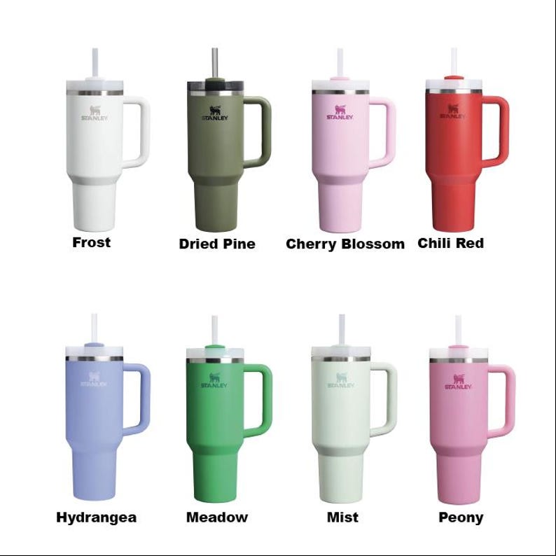 Puede incluir: Una colecci&oacute;n de ocho vasos Stanley en varios colores, incluyendo blanco, verde, rosa y rojo. Cada vaso tiene un asa, una pajita y el logotipo de Stanley. Los colores est&aacute;n etiquetados: Frost, Dried Pine, Cherry Blossom, Chili Red, Hydrangea, Meadow, Mist y Peony.