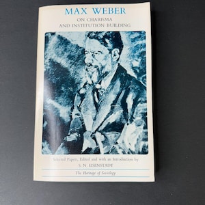 May include: A book cover with a blue and white image of Max Weber, the title "Max Weber on Charisma and Institution Building", and the text "Selected Papers, Edited and with an Introduction by S. N. EISENSTADT The Heritage of Sociology".