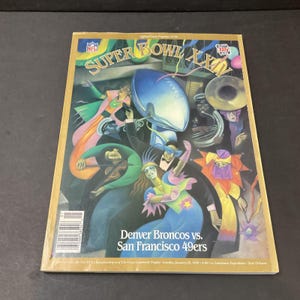 Può includere: Un programma vintage del Super Bowl XXIV con opere d'arte colorate di musicisti e ballerini. La copertina mostra il logo NFL e il testo "Super Bowl XXIV". Il programma mette in evidenza la partita Denver Broncos contro San Francisco 49ers.
