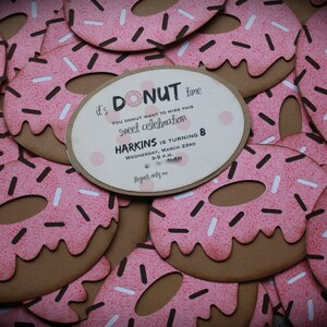 May include: It's donut time! A pink and brown donut-shaped invitation with white and brown sprinkles. The invitation reads "It's donut time! You donut want to miss this sweet celebration. Harkins is turning 8. Wednesday, March 23rd, 3-5 p.m. RSVP by March 10."