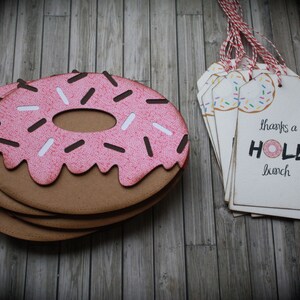 May include: A stack of donut-shaped thank you tags with pink icing and sprinkles. The text on the tag reads "thanks a HOLE bunch".