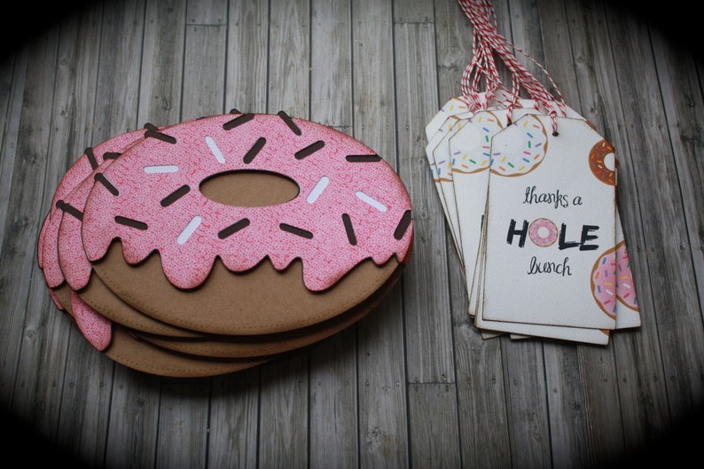 May include: A stack of donut-shaped thank you tags with pink icing and sprinkles. The text on the tag reads "thanks a HOLE bunch".