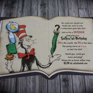 May include: A book-shaped invitation featuring an illustration of the Cat in the Hat. The invitation is for Sally's 1st birthday party, taking place on the 7th of July at 11 a.m. The text reads "You could not, should not. Would not. want to miss a celebration quite like this! Join us for a SEUSSICAL celebration for Sally's 1st Birthday July is the month, the 7th is the date.... The party starts at 11 a.m. so don't be late! Would you, could you Come and play? Please let us know either way. RSVP at cativthehat.com"