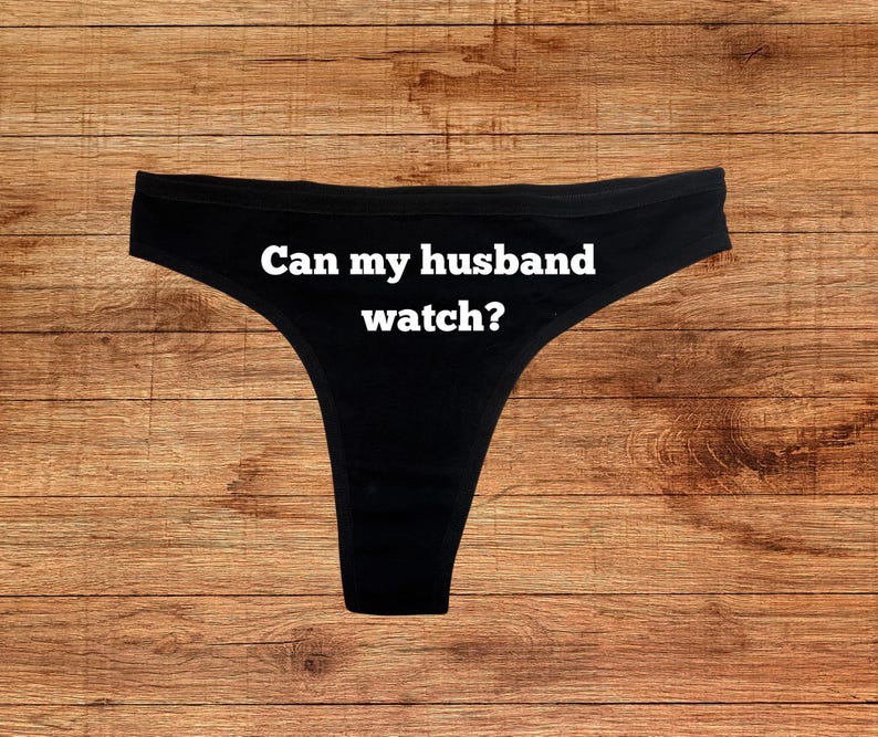 May include: Black lace underwear with the text "Can my husband watch?" printed in white.