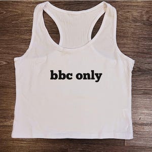 May include: White tank top with the text "bbc only" printed in black.