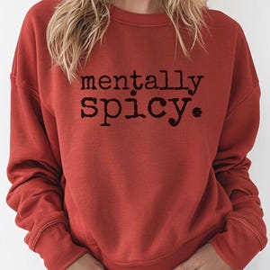 May include: A red sweatshirt with the text "mentally spicy." printed in black.