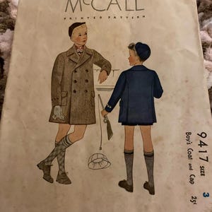May include: A vintage McCall printed pattern envelope, number 9417, for a boy's coat and cap. The illustration features two figures wearing coats, caps, and knee-high socks. The text includes 'McCALL PRINTED PATTERN', '9417', 'SIZE 3', and '25c'.
