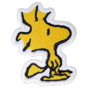 May include: Yellow embroidered iron-on patch of the Peanuts character Woodstock, a yellow bird with black outlines.