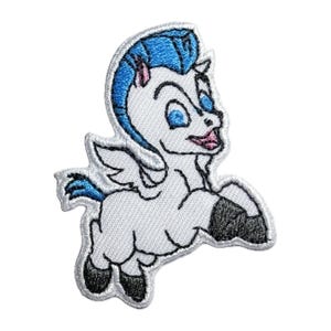 Könnte beinhalten: Gestickter Bügel-Aufnäher mit einem weißen geflügelten Pferd mit blauen Haaren und schwarzen Hufen. Das Pferd hat einen rosa Mund und blaue Augen.