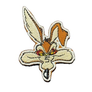 Peut inclure: Écusson brodé représentant un coyote de dessin animé avec une expression déterminée. L'écusson est de couleur beige et orange avec des coutures détaillées. Les yeux du coyote sont rouges et jaunes, et l'écusson a une bordure blanche.