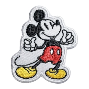 May include: A white embroidered patch featuring Mickey Mouse with black outlines, red shorts, and yellow shoes. Mickey Mouse is giving a thumbs up with both hands.