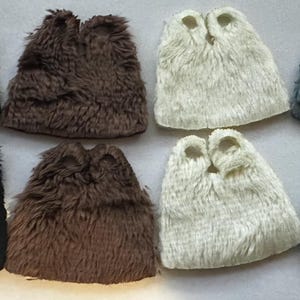 Puede incluir: Ocho cubiertas de bota de piel sintética en varios colores: negro, marrón, crema y gris. Cada cubierta tiene una forma redondeada con dos agujeros en la parte superior. Las cubiertas están dispuestas en dos filas de cuatro.