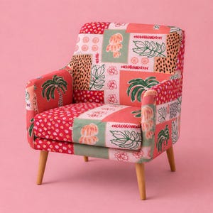 May include: Upholstered armchair with a patchwork design featuring palm trees, flowers, and leaf patterns in red, pink, green, and cream. The chair has light wooden legs and armrests.