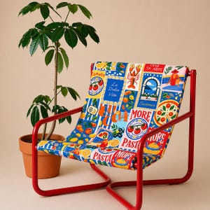 May include: A red metal frame chair with a colorful fabric seat featuring Italian food illustrations and the words "La Dolce Vita" and "Pasta More". A potted plant is in the background.