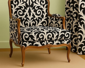 Könnte beinhalten: Gepolsterter Sessel mit einem schwarz-weißen Blumenmuster. Der Holzrahmen hat eine hellbraune Oberfläche. Der Stuhl hat geschwungene Beine und Armlehnen. Passende Vorhänge im Hintergrund.