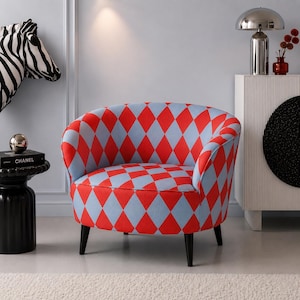 May include: A modern armchair with a red and light blue diamond pattern. The chair has a rounded back, armrests, and black legs. The chair is a statement piece for a living room or bedroom.