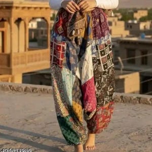 Puede incluir: Pantalones harén con patchwork multicolor. Los pantalones tienen un ajuste holgado y cómodo, de estilo bohemio. La tela es una mezcla de diferentes patrones y texturas, con colores como rojo, azul, verde y morado.
