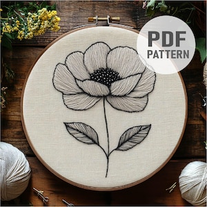 May include: A black and white embroidery pattern of a single flower with leaves in a wooden embroidery hoop. The pattern is labeled "PDF PATTERN".