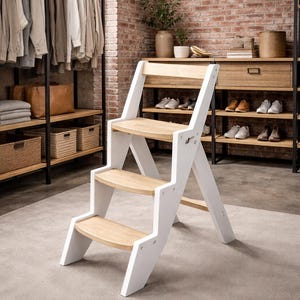Op de afbeelding: Een witte en naturel houten opstap met drie treden. De treden zijn gemaakt van lichtgekleurd hout en het frame is wit geschilderd. De opstap heeft een eenvoudig, modern ontwerp. De opstap staat op een neutraal gekleurd tapijt. De hoogte is ongeveer 80 cm.