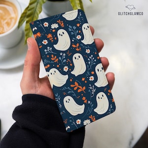 Puede incluir: Una funda de teléfono azul con un patrón de fantasmas blancos y flores. La funda tiene un diseño lindo y caprichoso.