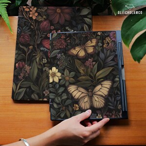 May include: Two decorative covers with a dark floral and butterfly design. One cover is open, revealing a black interior. The covers feature a variety of flowers and butterflies in shades of yellow, brown, and green.