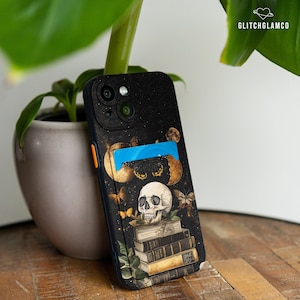 Può includere: Una custodia per telefono nera con un design di teschio e pila di libri. La custodia ha un porta carte blu e uno sfondo scintillante.