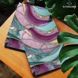May include: Two decorative covers with a stained glass design in shades of purple, teal, and pink, with gold accents. The covers are on a wooden surface, with the text "GLITCHGLAMCO" in the upper right corner.
