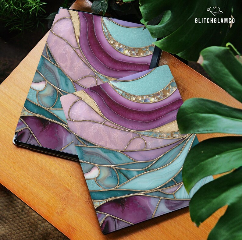May include: Two decorative covers with a stained glass design in shades of purple, teal, and pink, with gold accents. The covers are on a wooden surface, with the text "GLITCHGLAMCO" in the upper right corner.