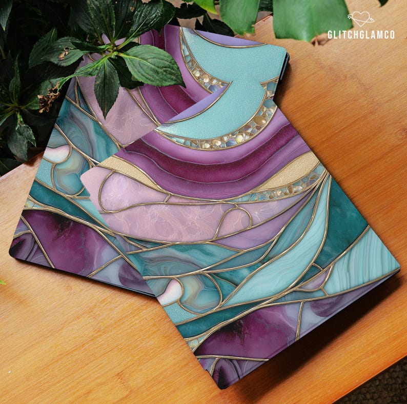 May include: Two decorative coasters with a stained glass design. The coasters feature a mix of purple, teal, and gold colors with a swirling pattern. The coasters are on a wooden surface. The text "GLITCHGLAMCO" is visible in the upper right corner.