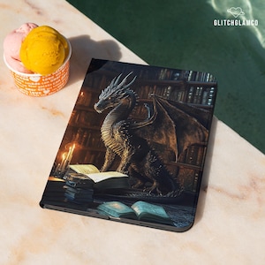 Könnte beinhalten: Eine schwarze Tablet-Hülle mit einer detaillierten Illustration eines Drachen in einer Bibliothek. Der Drache ist dunkel mit komplizierten Schuppen und Flügeln, umgeben von Büchern und Kerzenlicht. Das GlitchGlamco-Logo ist sichtbar.