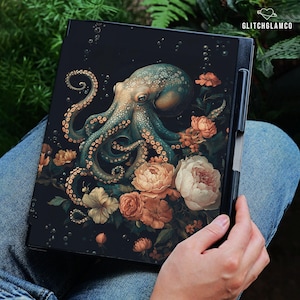 May include: A black tablet case featuring a teal octopus design surrounded by peach and white flowers. The octopus has detailed tentacles and is set against a dark background. The text "GLITCHGLAMCO" is in the upper right corner.