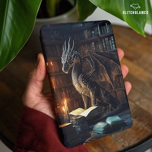 May include: A phone case featuring a detailed illustration of a dragon in a library setting. The dragon is dark gray with orange eyes, wings spread, and is surrounded by books and candles. The background shows bookshelves and a dimly lit room.