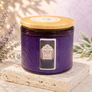 Pode incluir: Uma vela em frasco de vidro roxo com padrão floral em relevo e tampa de madeira clara. O rótulo diz Tranquility Sparks Candle Co. Violet Kush Serenity, 16 oz | 453 g, com ilustrações de lavanda e folhas num fundo branco.