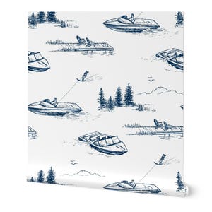 Op de afbeelding: Wit behang met een herhalend patroon van marineblauwe illustraties. Het ontwerp toont speedboten, waterskiërs, steigers met stoelen, bomen en vogels, wat een nautisch thema creëert.