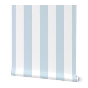 May include: A roll of wallpaper featuring a classic vertical stripe pattern. The design alternates between wide bands of light blue and white, creating a clean and simple aesthetic. The roll is partially unrolled, revealing the pattern.